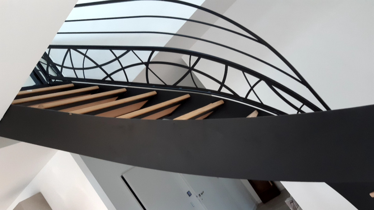 Escalier limon en c Marches en frêne, vernis 2 couches polyuréthane Garde corps, cadre en tube 40x20, 2 lisses D.13, soubassement en habillage décoratif courbes Triangulation, cadre en 40x20, remplissage en tôle décorative courbe+ arbre Ying Yang Laquage ral 9005 FT LAIGNELET 35133