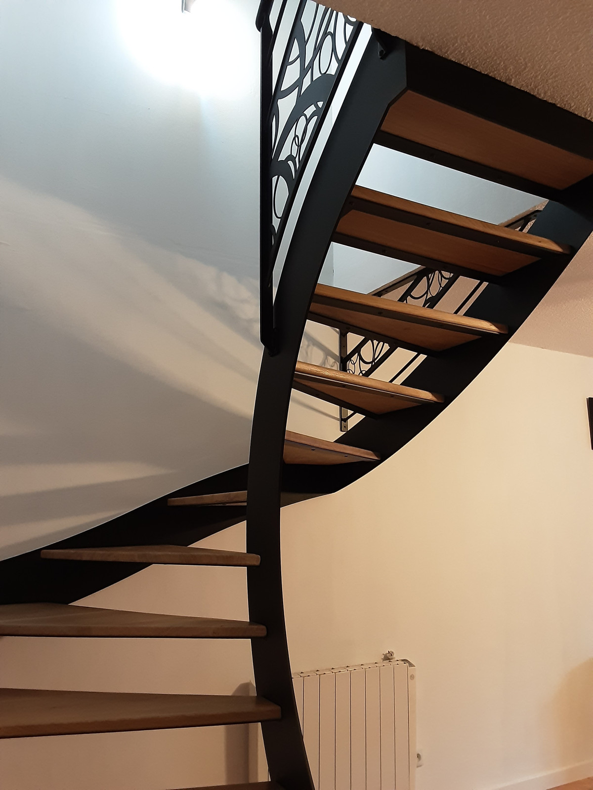 Escalier limon en C en acier Marches en chêne vitrifiées, vernis 2 couches polyuréthane Garde corps avec 1 lisse D.13 et un habillage décoratif, main courante D.42 Laquage ral 9005 FT 66600 Espira de L'agly