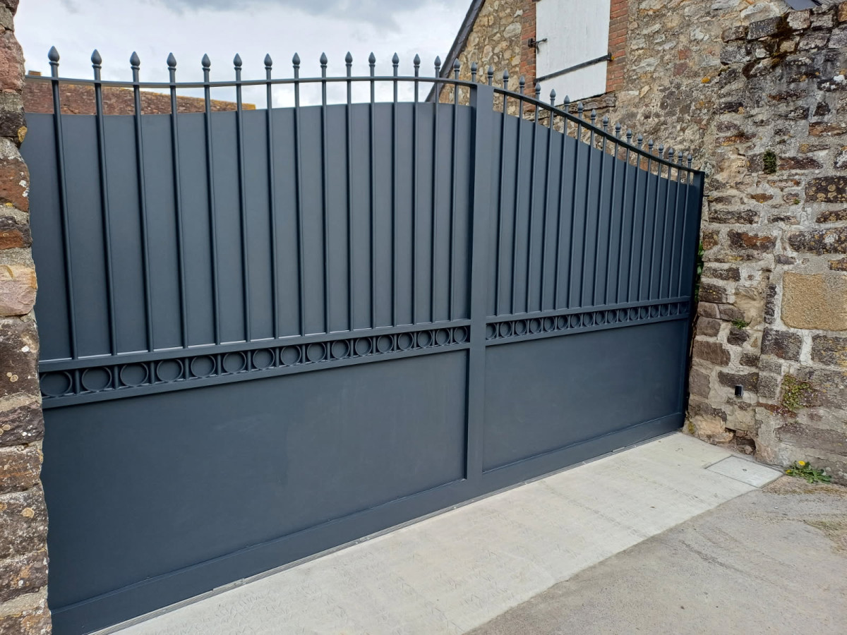 Portail coulissant forme chapeau de gendarme en aluminium Barraudage, festonnage, soubassement en tôles, volutes, fer de lances Laquage ral 7016 FT 53270 CHAMMES
