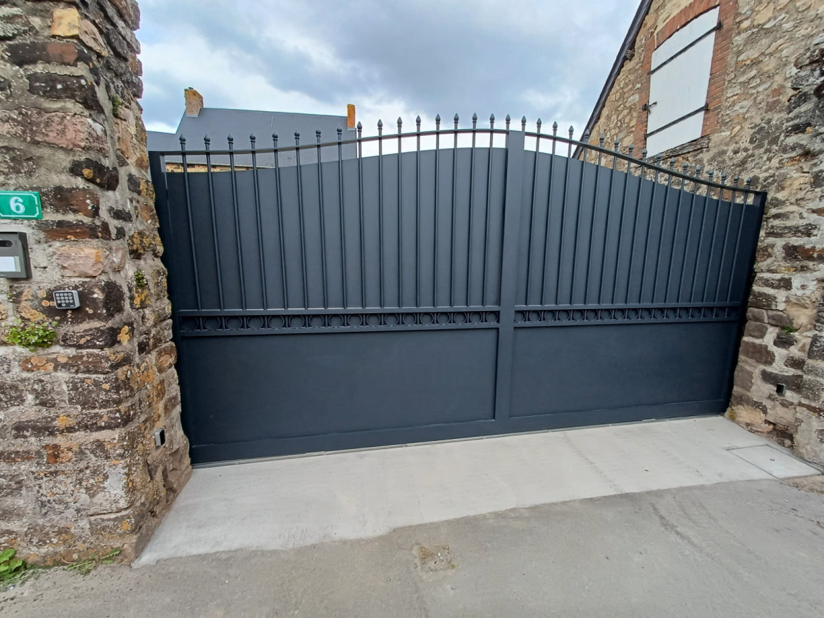 Portail coulissant forme chapeau de gendarme en aluminium Barraudage, festonnage, soubassement en tôles, volutes, fer de lances Laquage ral 7016 FT 53270 CHAMMES