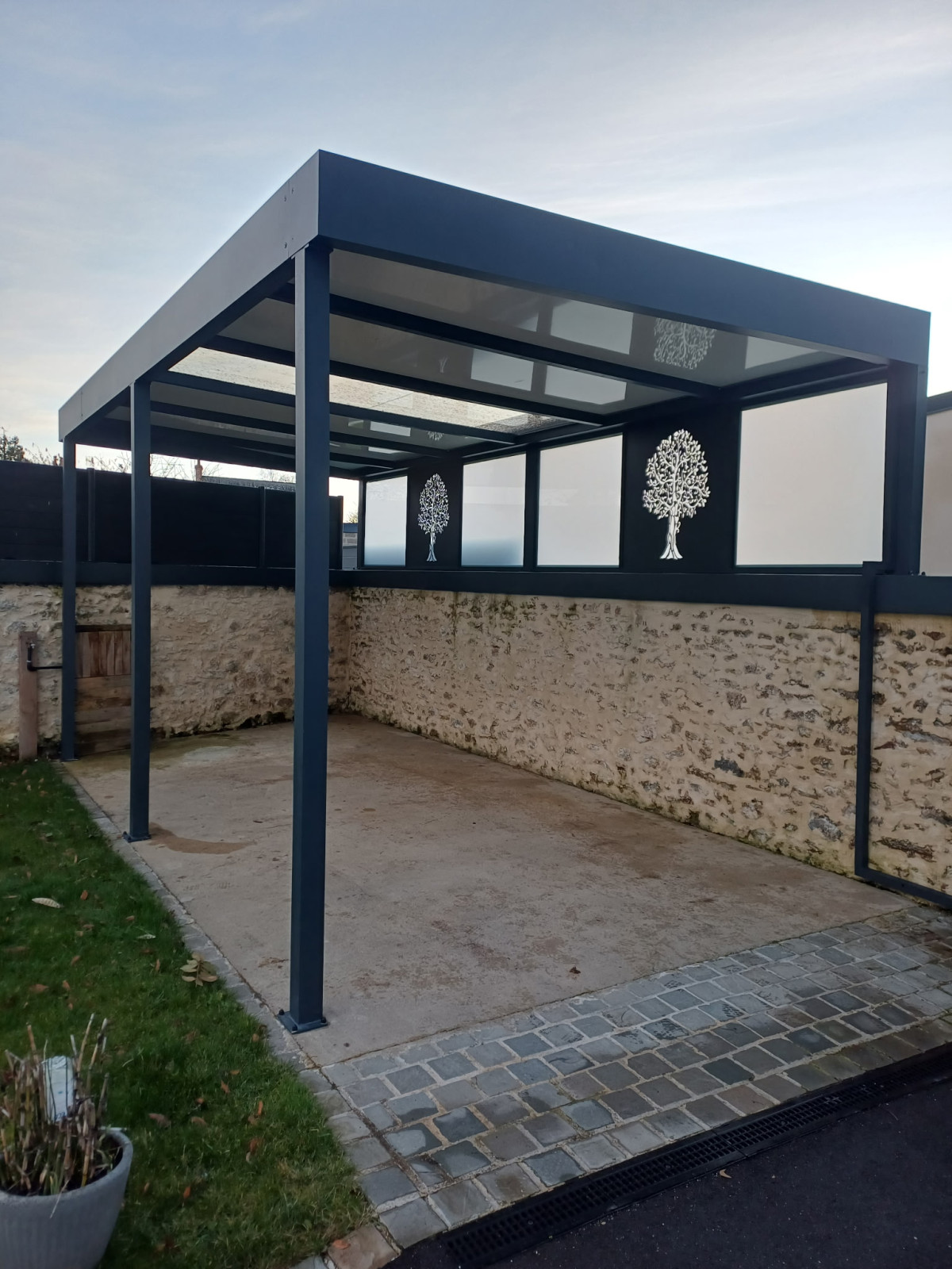 Pergola Toiture en panneau compressé Isotoit Panneau vitré et habillage décoratif "arbre" Laquage ral 7016 FT 53600 Evron