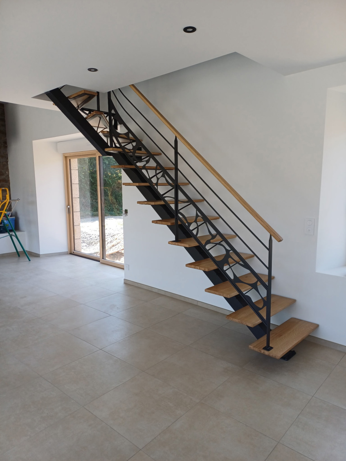 Fabrication d'un escalier limon central 1/4 tournant en acier Marches et main courantes en chêne Garde corps en acier, poteaux plats, 2 lisses D.13, soubassement en habillage décoratif. Laquage ral noir 2100 sablé 53300 ST FRAIMBAULT DE PRIERES