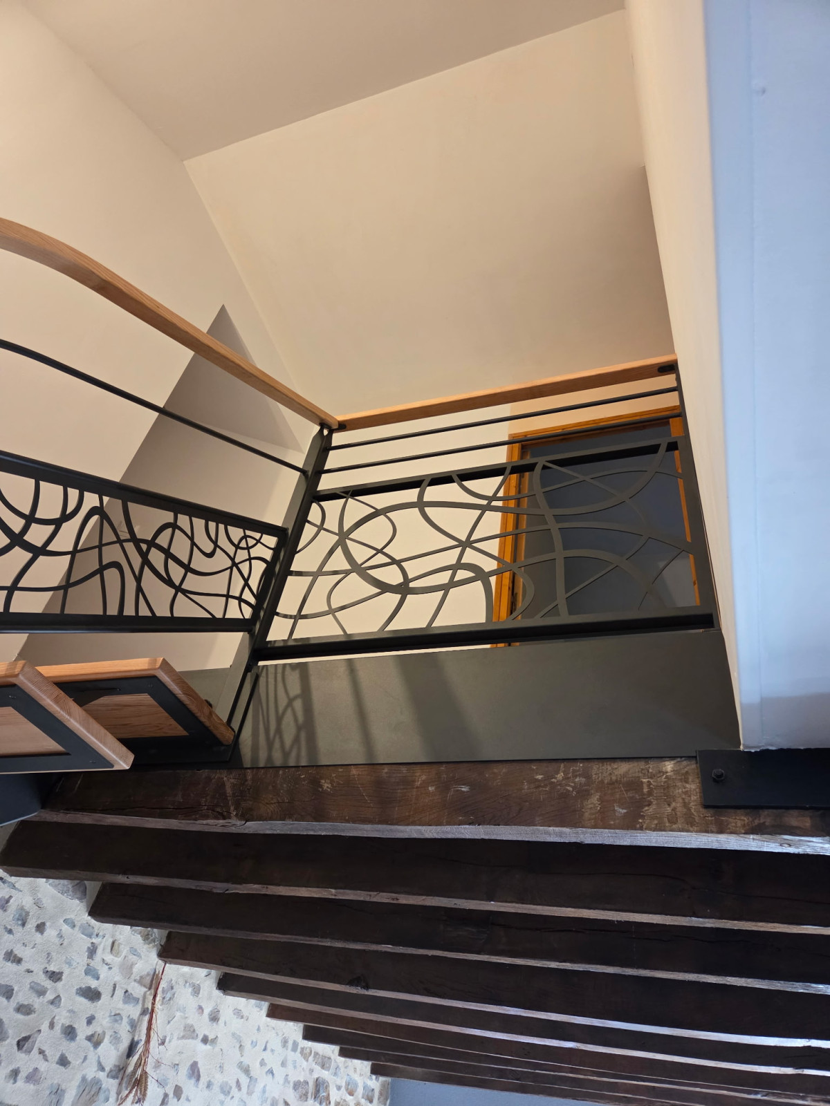 Fabrication escalier limon central 1/4 tournant en acier Marches en frêne Garde corps en acier, poteaux plats, 1 lisse D.13, soubassement en habillage décoratif arbre situé sur le milieu du rampant Laquage ral noir 2100 sablé 53600 CHATRES LA FORET