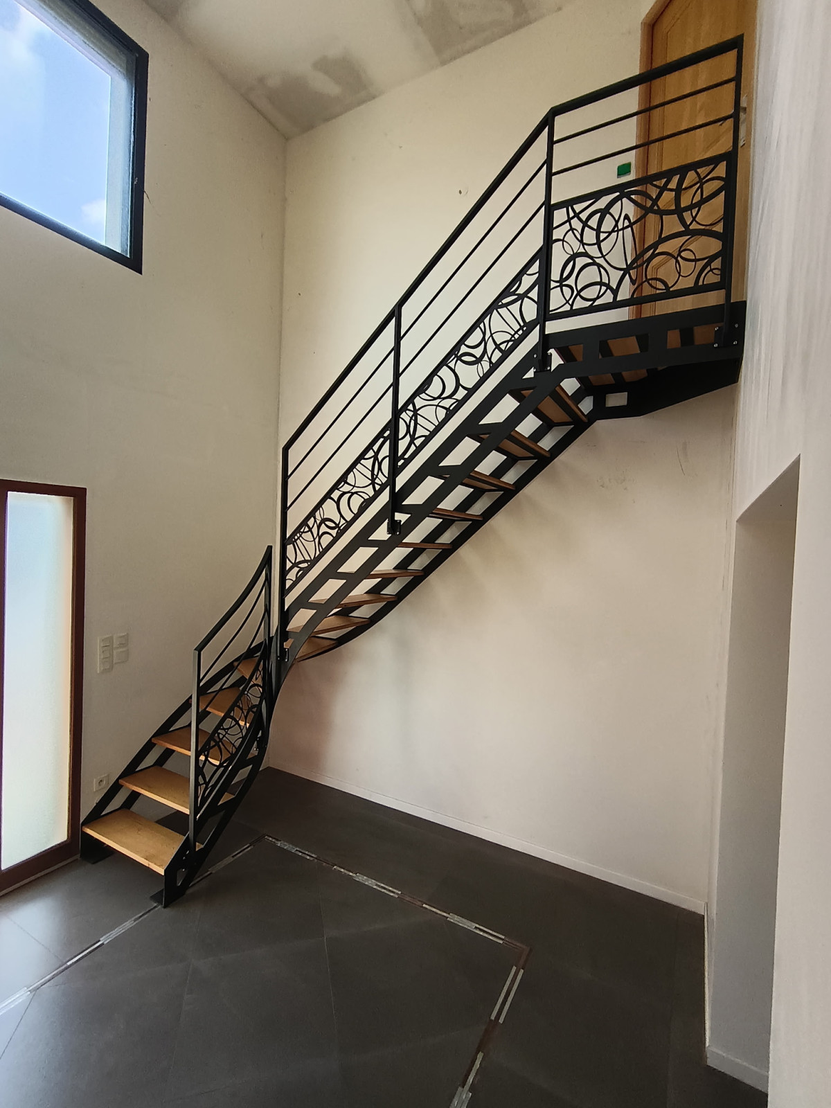Escalier doubles limons 1/4 tournant, limon découpe laser. Marches en chêne + palier Garde corps, ossature en cadre, 2 lisses, soubassement en habillage décoratif "ovales décalé" Laquage ral noir 2100 sablé 53480 ST GEORGES LE FLECHARD