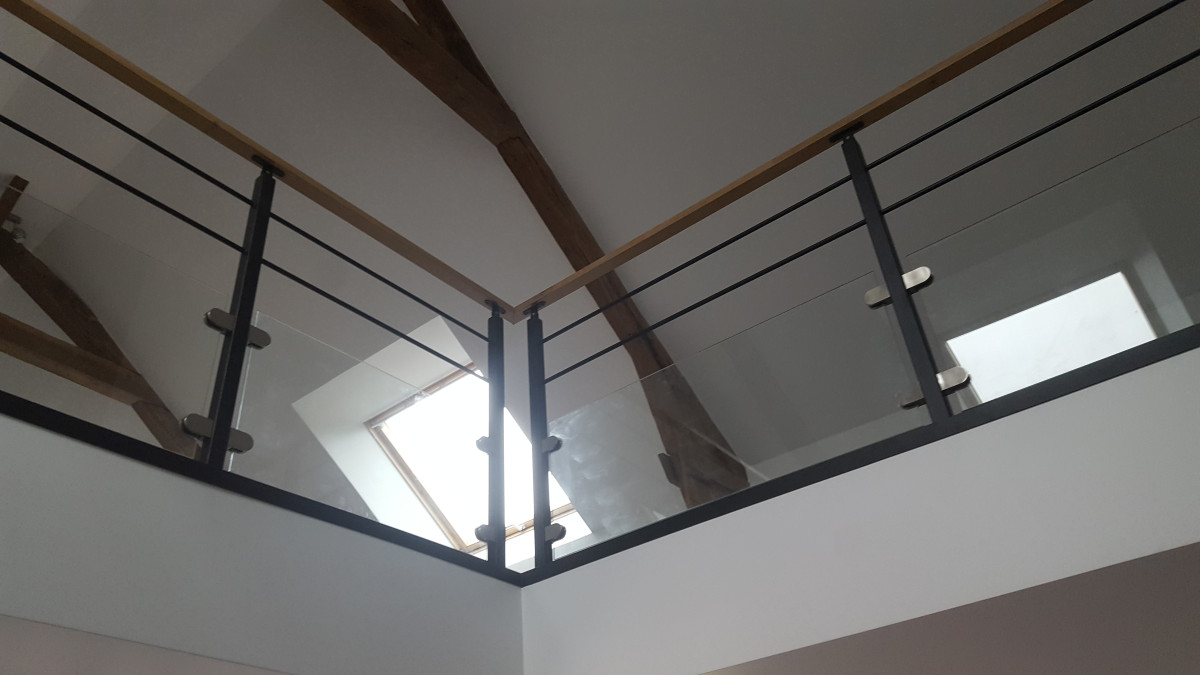 Garde corps en acier, poteaux plats, 2 lisses D.13, soubassement en vitrage clair 44/2 JPP, fixation sur pinces, main courante 50x30 mm en bois, laquage ral 9005 FT.