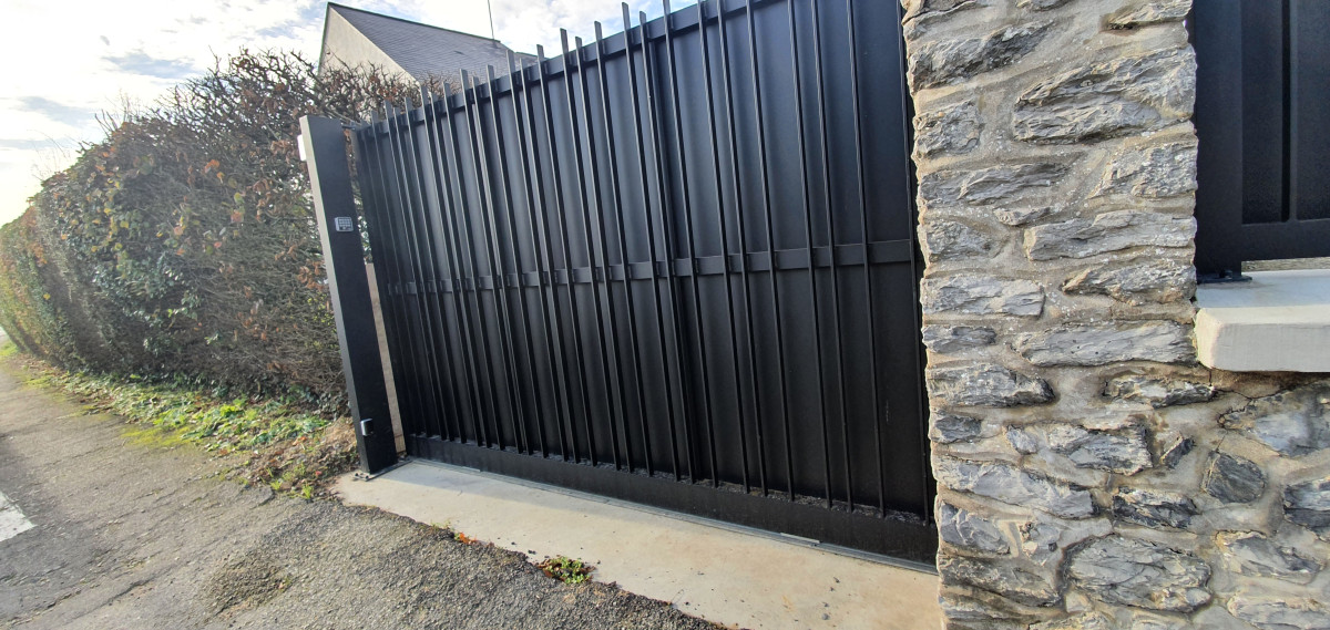 Portail coulissant en aluminium, ossature en tube 60x60, renfort en tube 30x30, remplissage en tôle et fer plat 30x10, laquage ral 7016 FT. 53000 LAVAL.