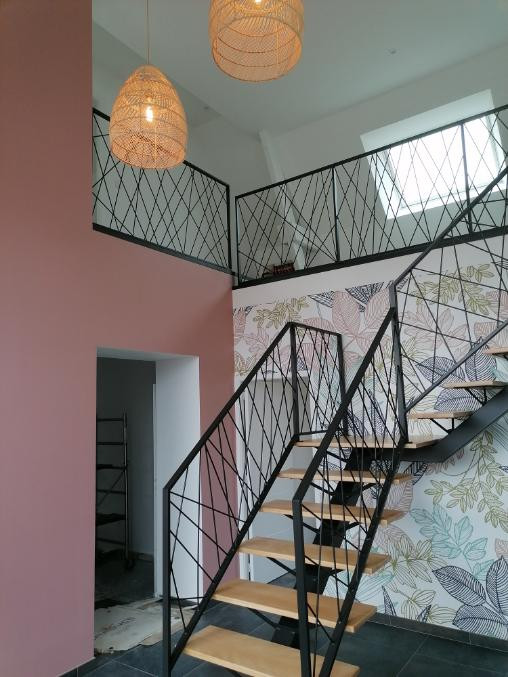 Escalier limon central en acier, 1/4 tournant avec palier intermédiaire, marche chêne vitrifiée 2 couches, garde corps en acier, cadre en 40x20mm, remplissage en lisses entremêlées, laquage ral noir 9005 FT.