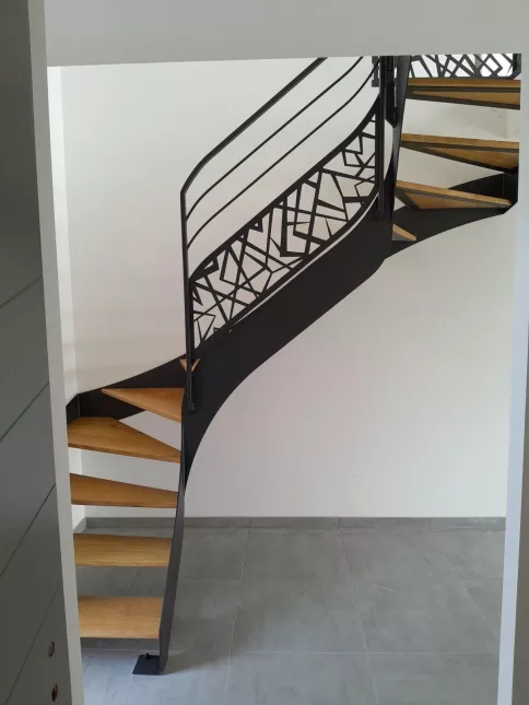 Escalier double limons 2/4 tournant en acier Marche en chêne Garde corps en acier, cadre en tube 40x20mm, 2 lisses 12x12mm, soubassement en tôle décorative "cardiaque" Triangulation, remplissage en tôle décorative "cardiaque" Laquage ral noir 2100 sablé 53100 MAYENNE