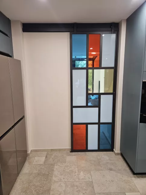 Fabrication d'une porte verrière coulissante châssis en acier Remplissage en vitrages de différentes couleurs Laquage compris noir 2100 sablé 53600 EVRON