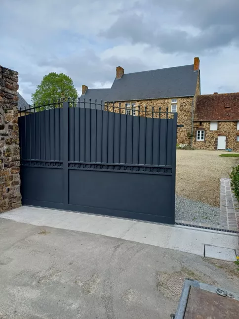 Portail coulissant forme chapeau de gendarme en aluminium Barraudage, festonnage, soubassement en tôles, volutes, fer de lances Laquage ral 7016 FT 53270 CHAMMES