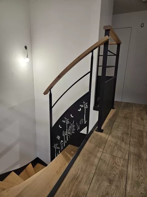 Escalier double limons en acier Marches et main courante en bois Garde corps en acier, lisses D.13, soubassement en habillage décoratif "fleurs- papillons". 53440 GRAZAY