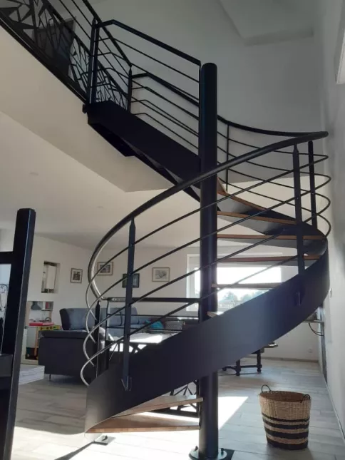 Escalier hélicoïdal en acier, marche en chêne vitrifiée 2 couches, garde corps en acier, 4 lisses D.16, main courante D.42.