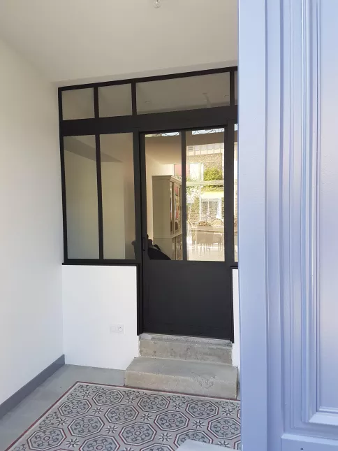 Verrière + porte ouvrante en aluminium, avec traverse intermédiaire, verre clair en 33/2 feuilleté, soubassement en tôle pour la porte, laquage ral noir 9005 FT.