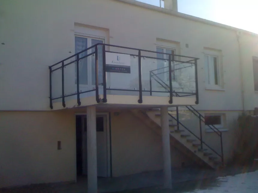 Garde corps de balcon, poteaux plats, remplissage en vitrage trempé, fixation sur pinces, main courante D.40, laquage ral 9005.