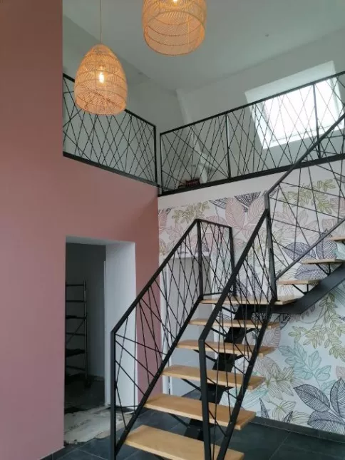 Escalier limon central en acier, 1/4 tournant avec palier intermédiaire, marche chêne vitrifiée 2 couches, garde corps en acier, cadre en 40x20mm, remplissage en lisses entremêlées, laquage ral noir 9005 FT.