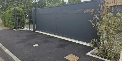 Portail coulissant en aluminium, remplissage en lames avec un habillage décoratif "fleurs" + inscription adresse. Laquage ral 7016 FT 53600 CHATRES LA FORET
