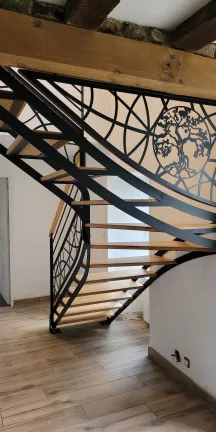 Escalier double limons découpé, 1/4 tournant Garde corps en acier, poteaux plats, 2 lisses D.13, soubassement en tôle décorative courbe Triangulation, cadre en fer plat, remplissage en tôle décorative courbe+arbre Laquage ral 9005 FT Marches+ main courante en chêne vernis 2 couches polyuréthane 53600 ST GEMMES LE ROBERT