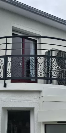 Garde corps de balcon cintré en aluminium Poteaux plat, 2 lisses, soubassement en habillage décoratif "nénuphar", main courante en tube rond, laquage ral 7016 FT. 53600 EVRON