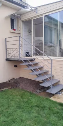 Escalier extérieur 6 marches + 1 palier. Marches en acier larmés. Garde corps en aluminium, cadre 40x20mm, remplissage en lisses D.16 + soubassement habillage décoratif "spline" sur le garde corps droit. 53810 CHANGE