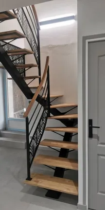 Escalier 2/4 tournant, limon central en acier Marches et main courante en chêne garde corps avec 2 lisses+ habillage décoratif "oriental" Laquage ral noir 9005 FT 72140 ROUESSE-VASSE