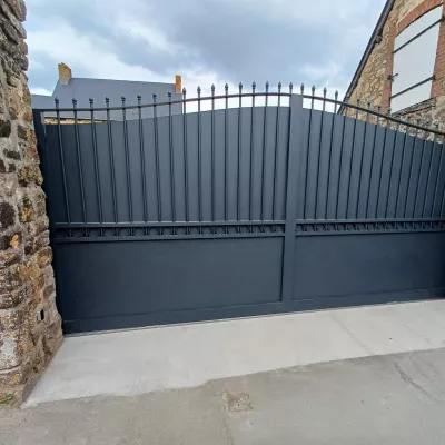 Portail coulissant forme chapeau de gendarme en aluminium Barraudage, festonnage, soubassement en tôles, volutes, fer de lances Laquage ral 7016 FT 53270 CHAMMES