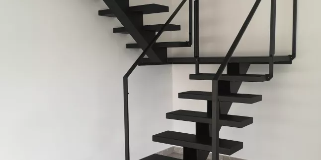 Escalier limon central en acier, 2/4 tournant, marches caissonnés. Garde corps en acier, ossature en tube rectangle, remplissage en vitrage JPP. Laquage ral noir 9005. 66300 PASSA
