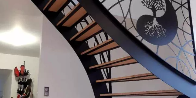 Escalier limon en c Marches en frêne, vernis 2 couches polyuréthane Garde corps, cadre en tube 40x20, 2 lisses D.13, soubassement en habillage décoratif courbes Triangulation, cadre en 40x20, remplissage en tôle décorative courbe+ arbre Ying Yang Laquage ral 9005 FT LAIGNELET 35133