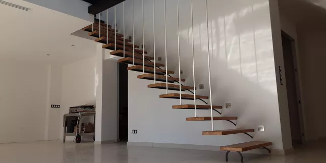 Escalier en acier Limon latéral, aspect suspendu Garde corps filant Lisses D.17 en acier Marches bois chêne vernis, 2 couches polyuréthane. 66690 Sorede