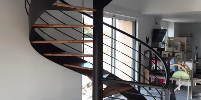 Escalier hélicoïdal en acier, marche en chêne vitrifiée 2 couches, garde corps en acier, 4 lisses D.16, main courante D.42.