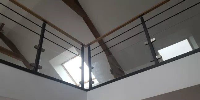 Garde corps en acier, poteaux plats, 2 lisses D.13, soubassement en vitrage clair 44/2 JPP, fixation sur pinces, main courante 50x30 mm en bois, laquage ral 9005 FT.