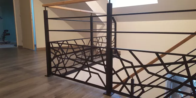 Garde corps en acier, poteaux en tube carré, 2 lisses D.13, soubassement en habillage décoratif cardiaque, main courante 50x30 mm en bois.