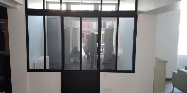 Porte verrière, avec traverse intermédiaire, soubassement en tôle sur la porte, verre clair en 33/2 feuilleté, ral noir 9005 FT.