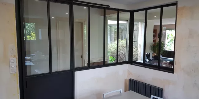 Verrière + porte coulissante en acier, sans traverse intermédiaire, soubassement en tôle pour la porte, roulette apparente, verre clair en 33/2 feuilleté, laquage ral noir 9005 FT.