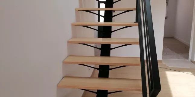 Escalier droit en acier, limon central, marche en chêne vitrifiée 2 couches, Garde corps en acier, poteaux plats, 4 lisses D.13, main courante en acier 50x30mm, laquage ral noir 9005 FT.