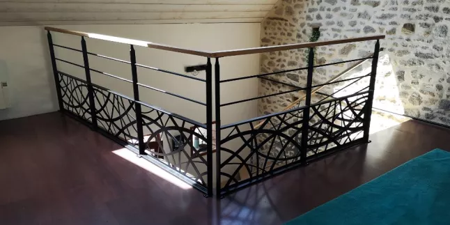 Garde corps en acier, poteaux plats, 2 lisses D.13, soubassement en habillage décoratif courbe, main courante 50x30 mm en bois. 