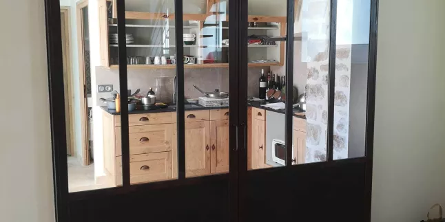 Porte verrière coulissante en acier, sans traverse intermédiaire, soubassement en tôle, verre clair en 33/2 feuilleté, roulettes apparentes, ral noir 9005 FT.