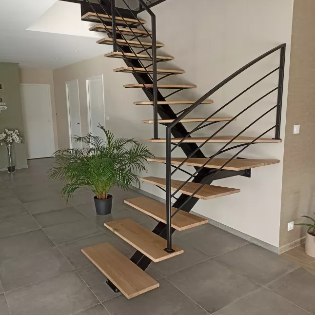 Escalier limon central, 1/4 tournant, sabots n°51, garde corps en acier, cadre en 40x20, remplissage en lisse D.13, garde corps droit avec un soubassement en habillage décoratif courbes, laquage ral 9005 FT. 35210 MONTREUIL DES LANDES.