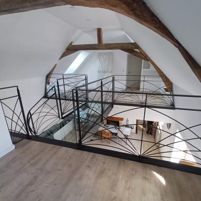 Escalier limon central 1/4 tournant débillardé, marches en chêne rustique sablé, laquage ral 2100 sablé Garde corps poteaux plats, remplissage lisses D.10 cintrées, main courante 40x10, laquage ral 2100 sablé Ossature en UPN, remplissage en dalle de verre clair, laquage de l'ossature ral noir 2100 sablé 72170 SEGRIE