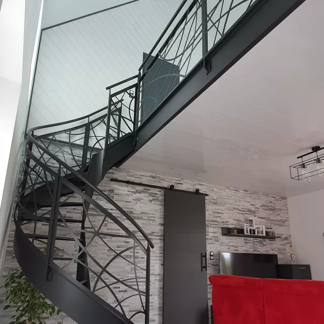 Escalier hélicoïdal en acier, marches en acier, garde corps avec habillage toute hauteur "courbes", main courante D.42.